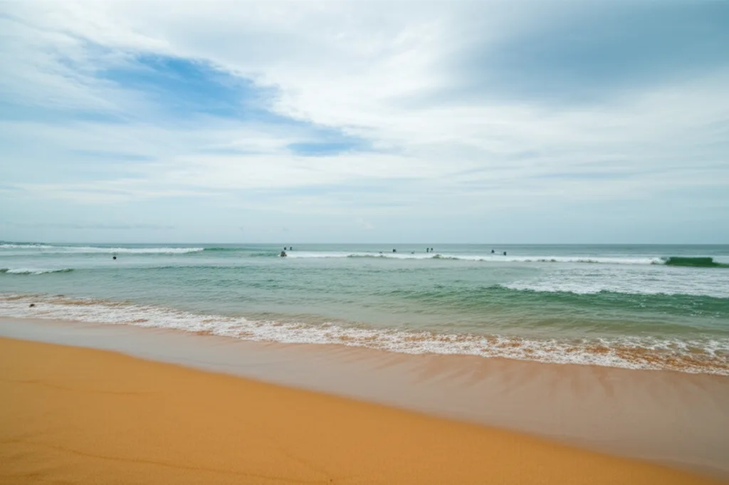 Lightly visited beach on Sri Lanka’s east coast with a few surfers in the water
